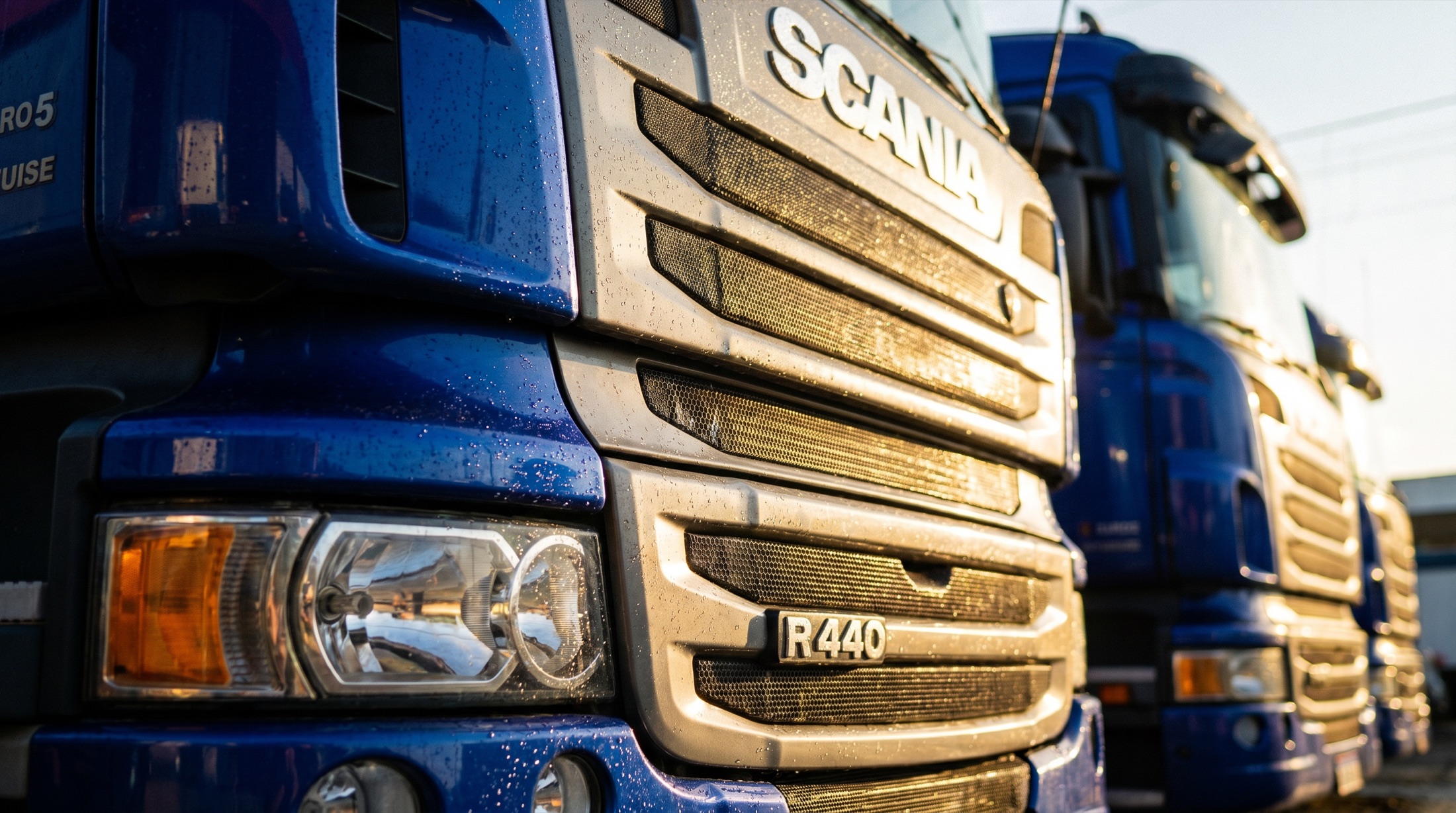 Detalhe da grade de um caminhão Scania ProdHigi sob luz quente